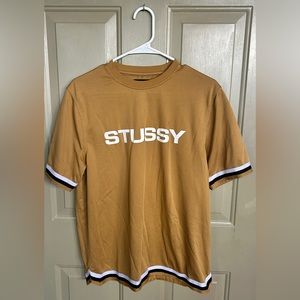 Gold Stussy Tee, light jersey material.